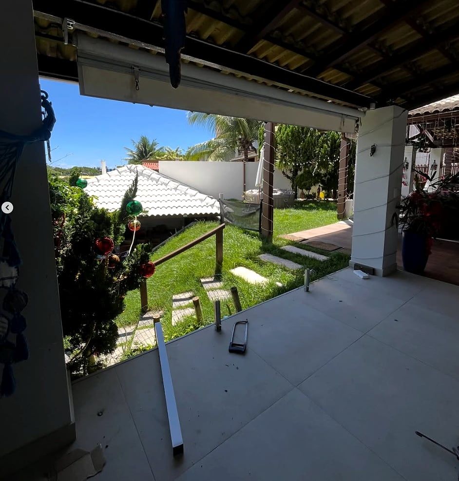 Varanda residencial antes da instalação: apenas os montantes metálicos fixados, sem os painéis de vidro